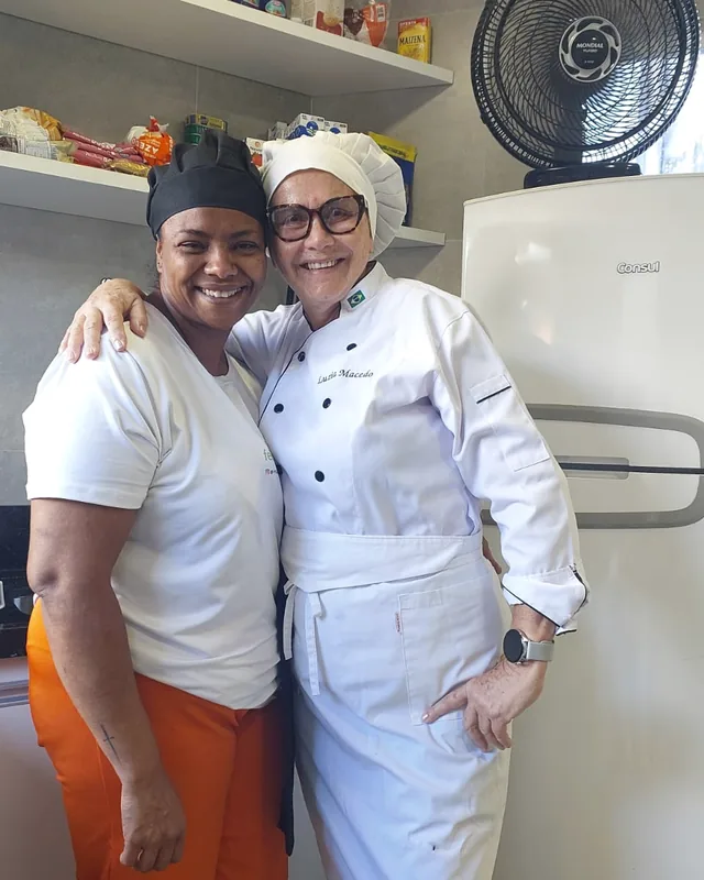 Luzia Macedo abraçada a uma integrante da equipe da cozinha.